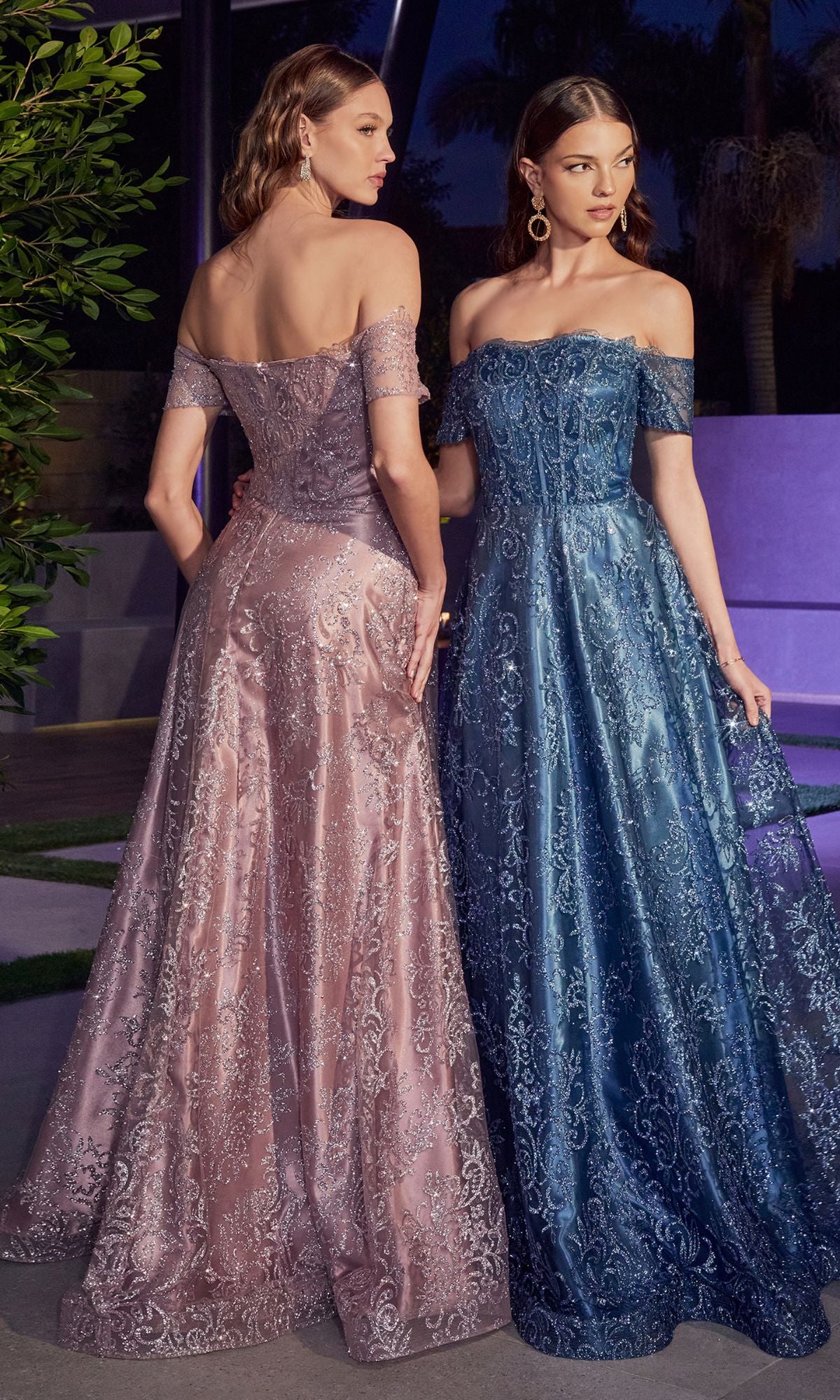 Two women stand side by side outdoors at dusk, each radiating elegance in a Glitter-Print Off-Shoulder Long Prom Dress J835—one wearing mauve lace, the other blue—both flaunting graceful, floor-length A-line silhouettes.